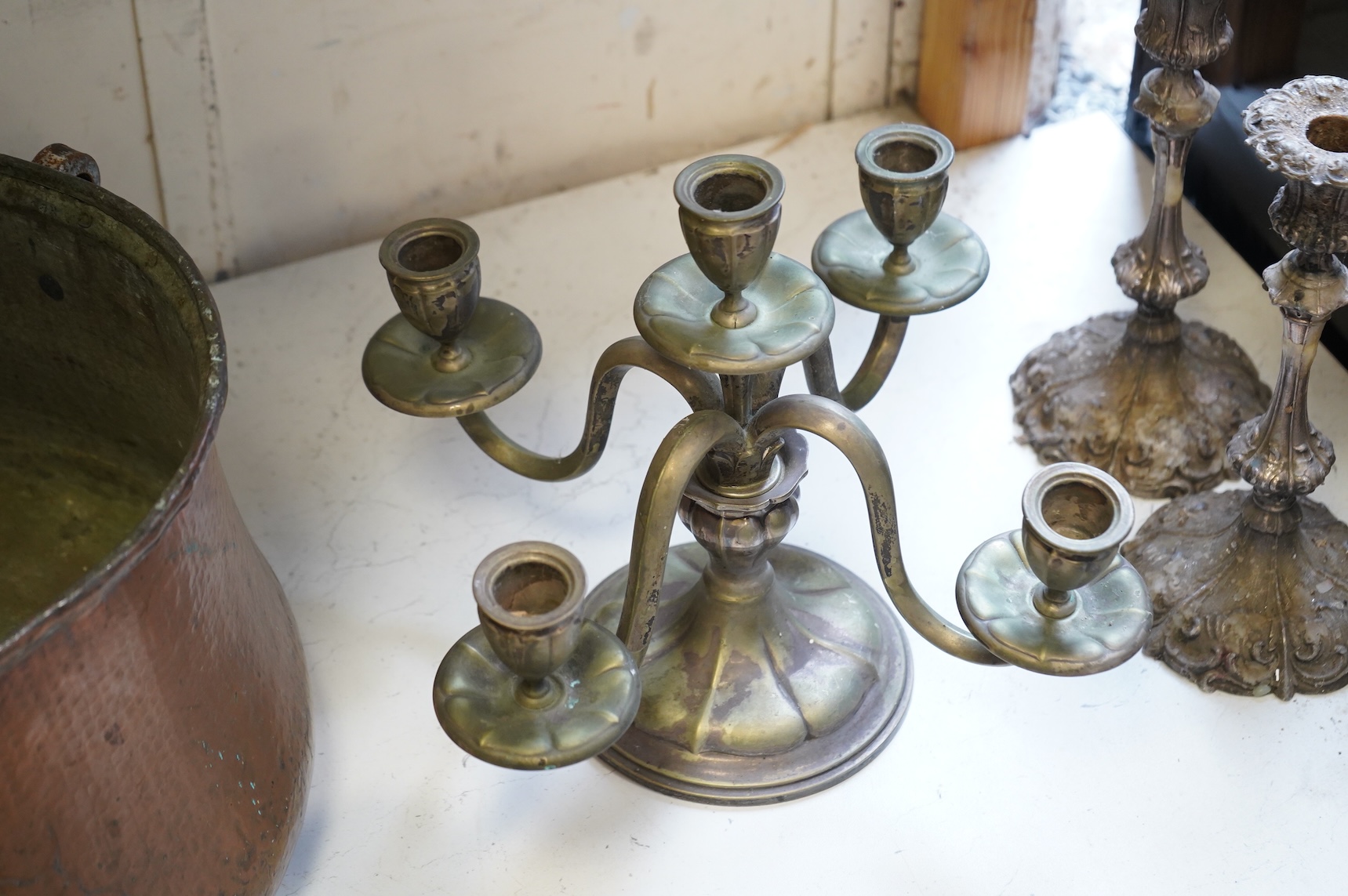 A pair of silver plated candlesticks, a four branch, three light candlestick and a copper cauldron